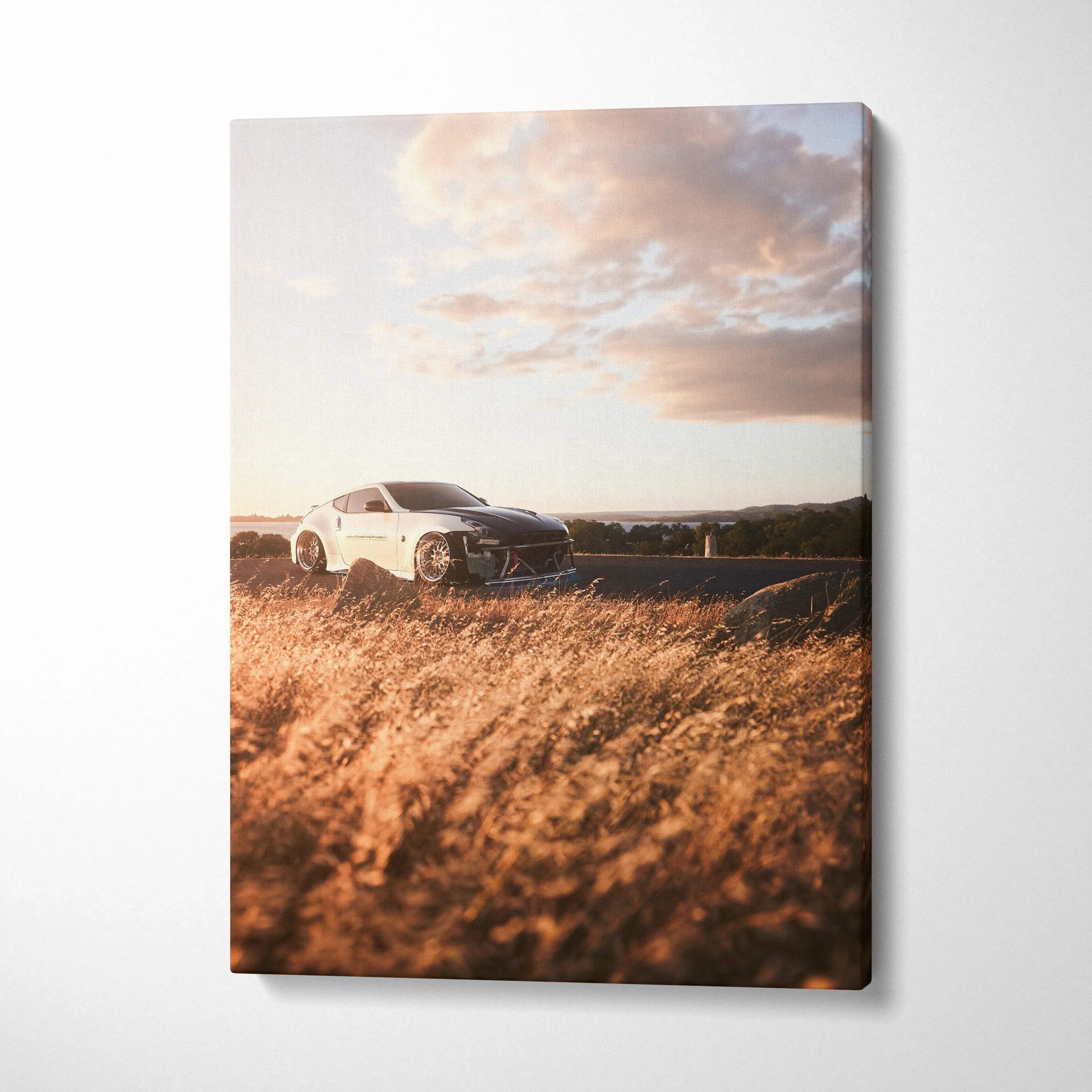 Nissan 370z driving on road during sunset canvas wall art with golden grass foreground.