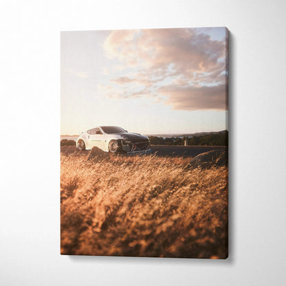 Nissan 370z driving on road during sunset canvas wall art with golden grass foreground.