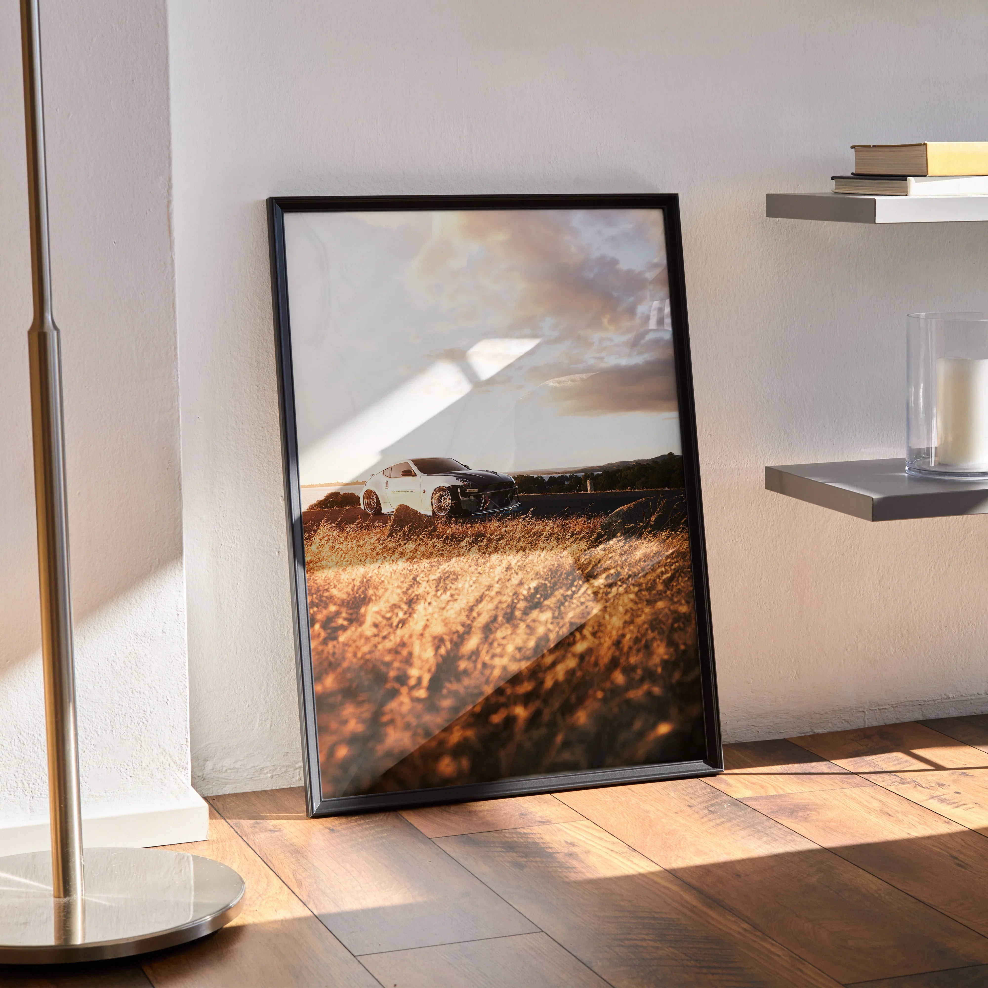 Nissan 370z poster wall art with car on grassy field under cloudy sky in black frame.