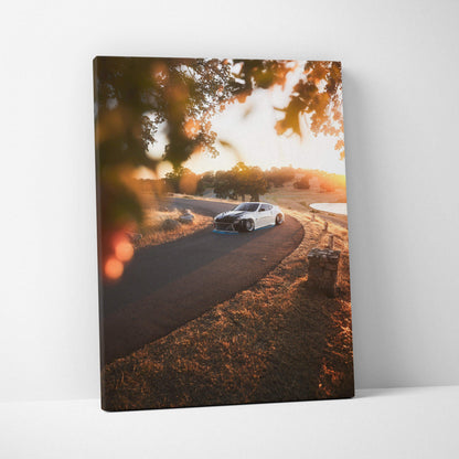 Nissan 370z driving on a winding road at sunset canvas wall art in warm tones.