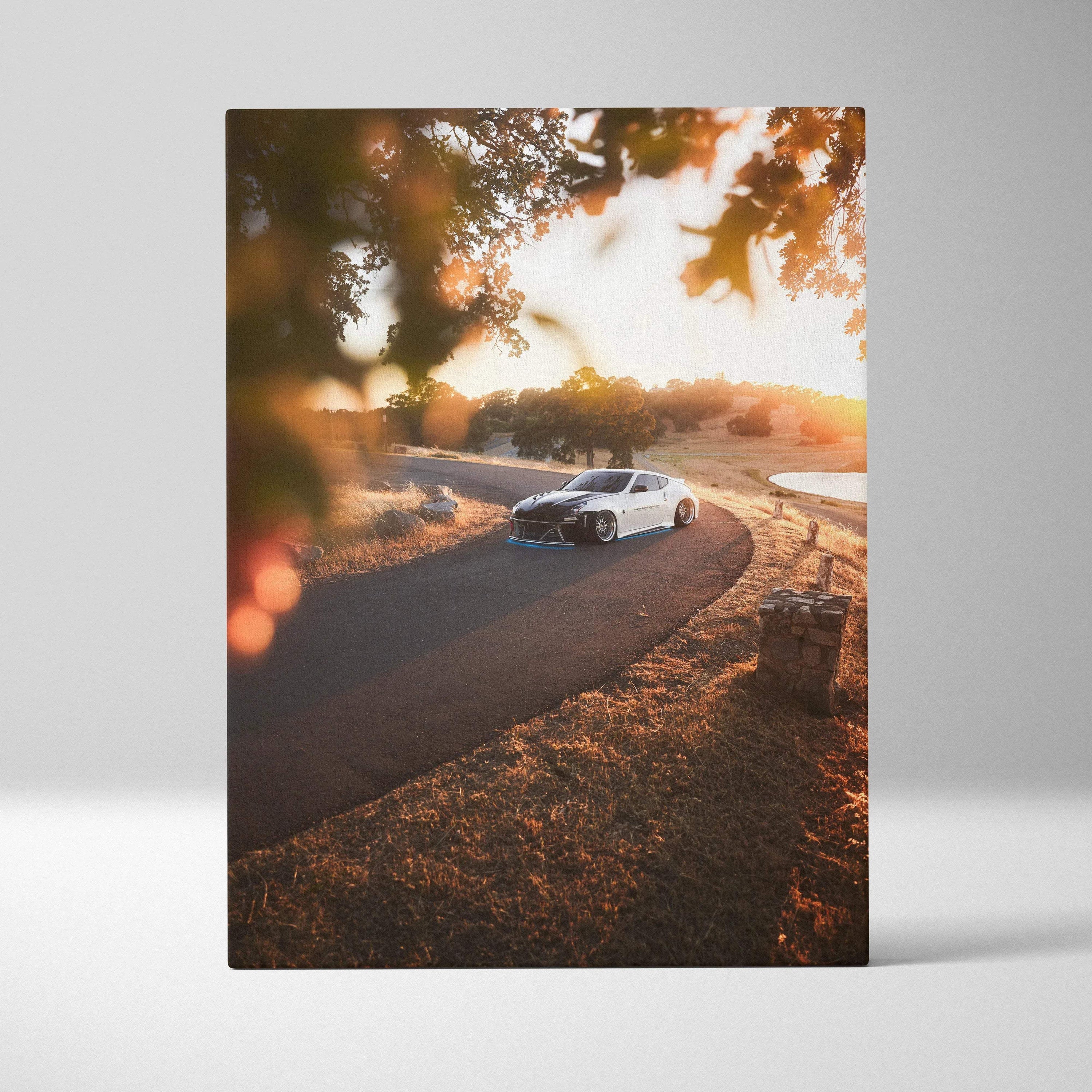 Nissan 370z driving on curved road at sunset canvas art with warm autumn tones wall art.