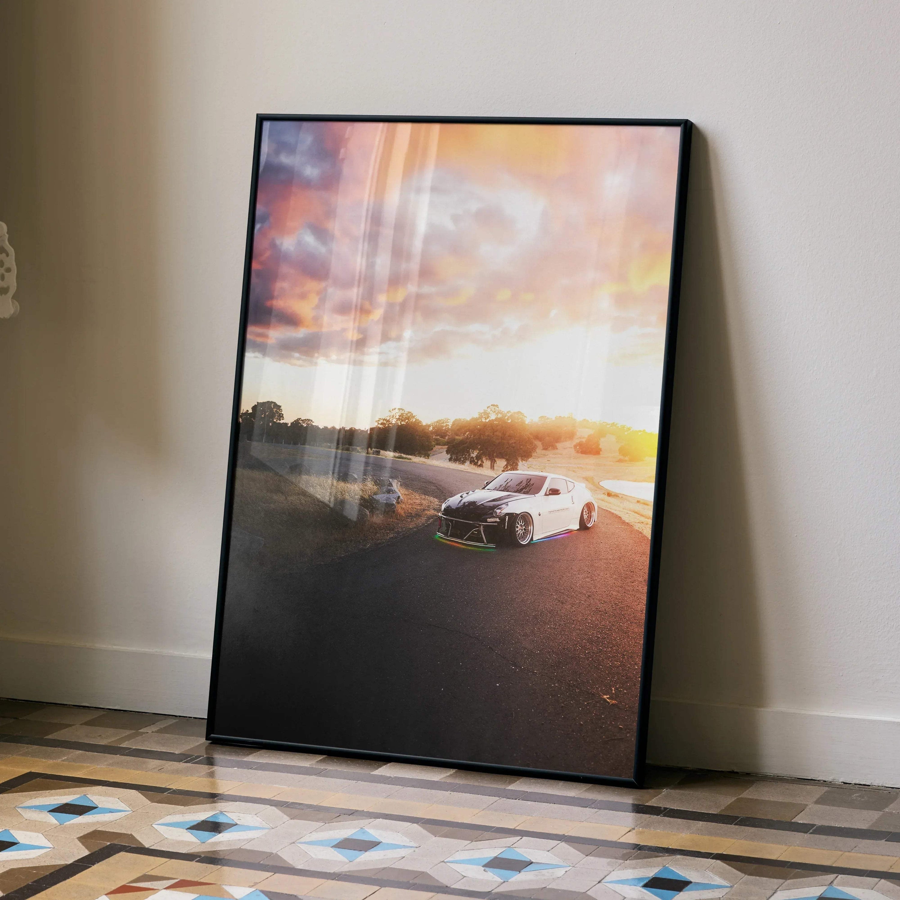 Nissan 370z poster wall art with sunset background in black frame leaning on beige wall.