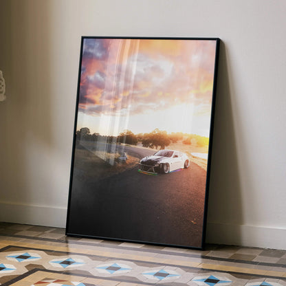 Nissan 370z poster wall art with sunset background in black frame leaning on beige wall.