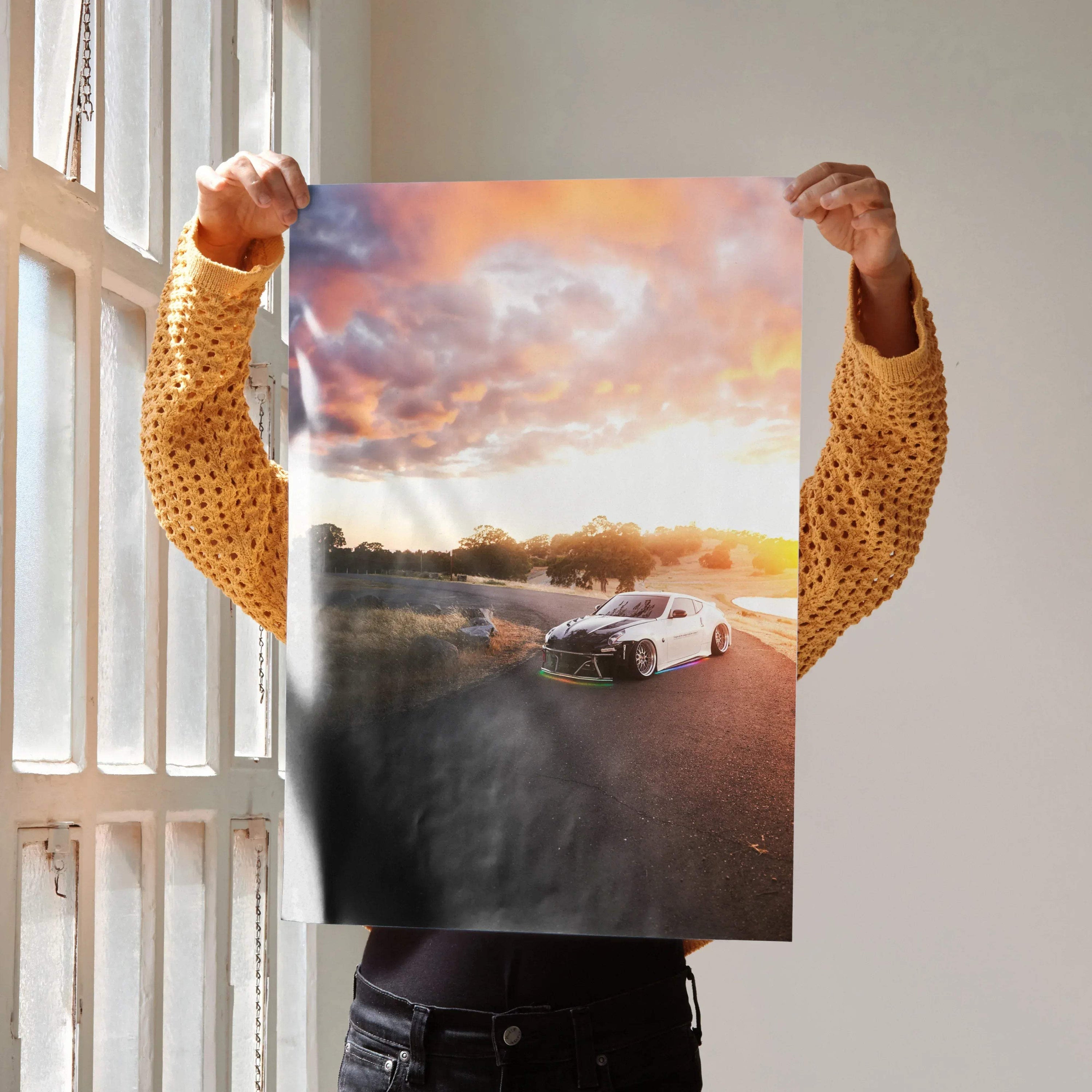 Sunset-lit Nissan 370z on road poster wall art with vibrant sky colors.