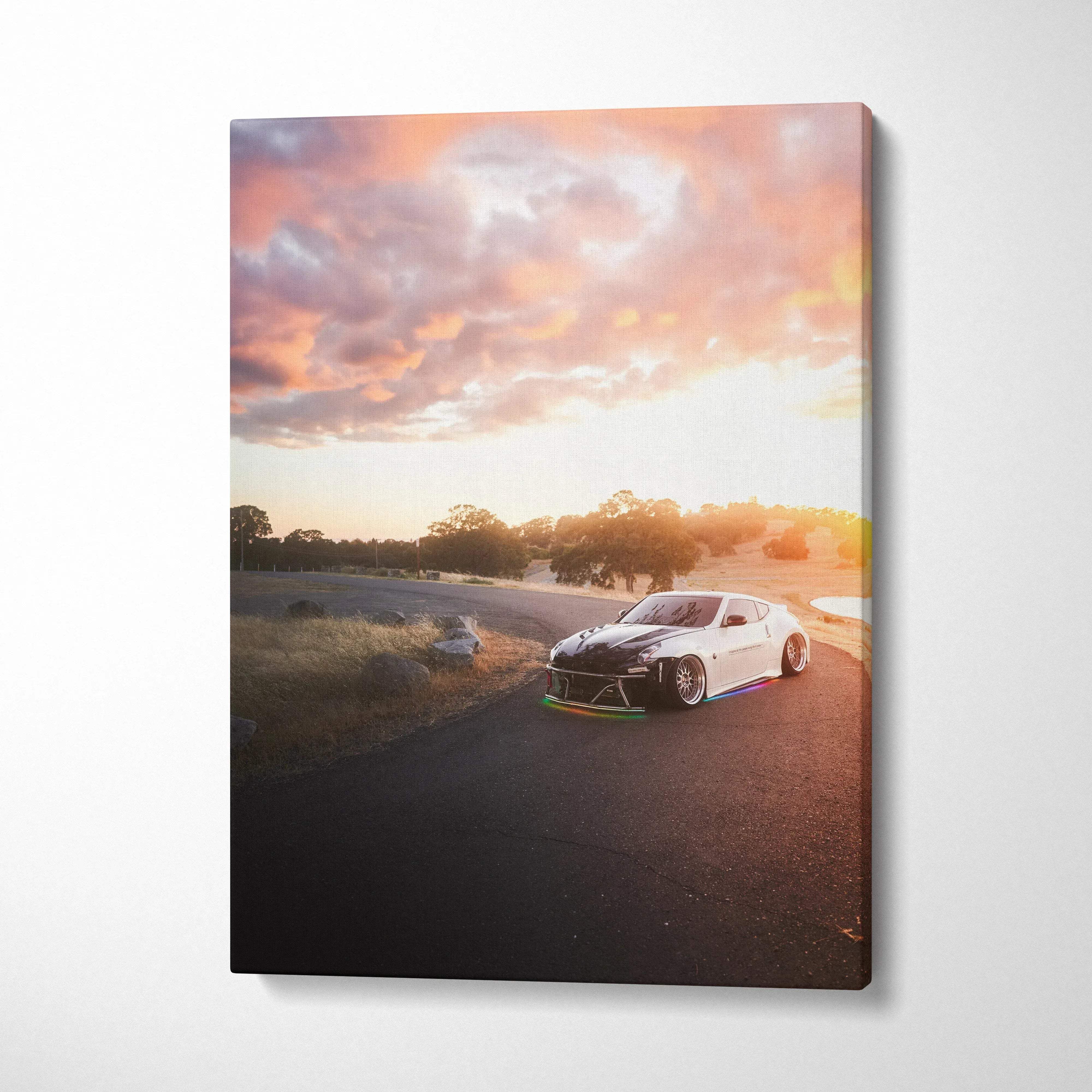 Nissan 370z driving on track at sunset canvas wall art with vibrant sky colors.