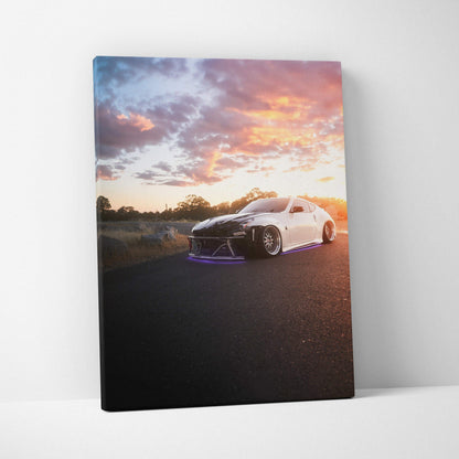 Vertical canvas wall art featuring a white Nissan 370z at sunset with vibrant sky colors.