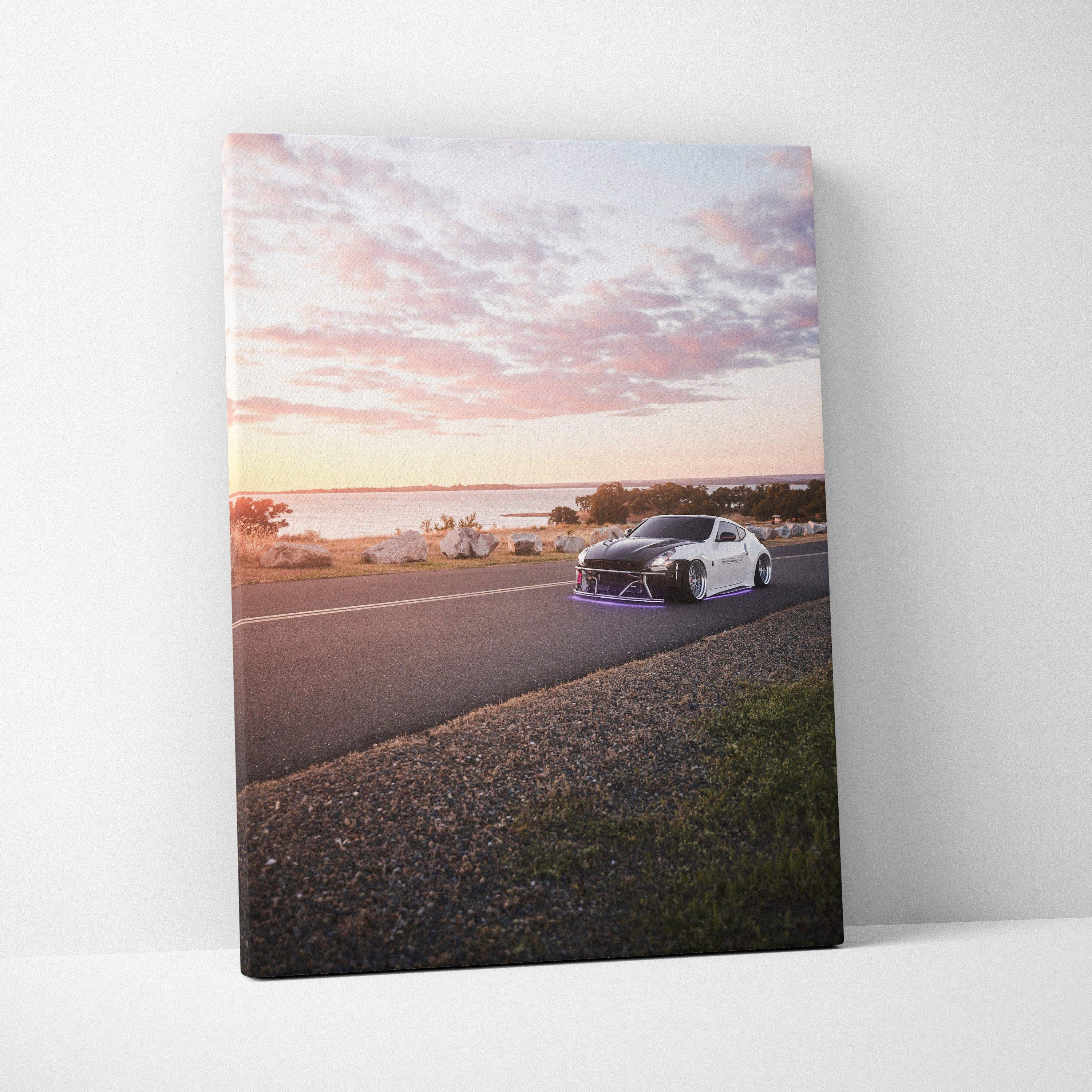 Nissan 370z driving on coastal road at sunset on vertical canvas wall art.