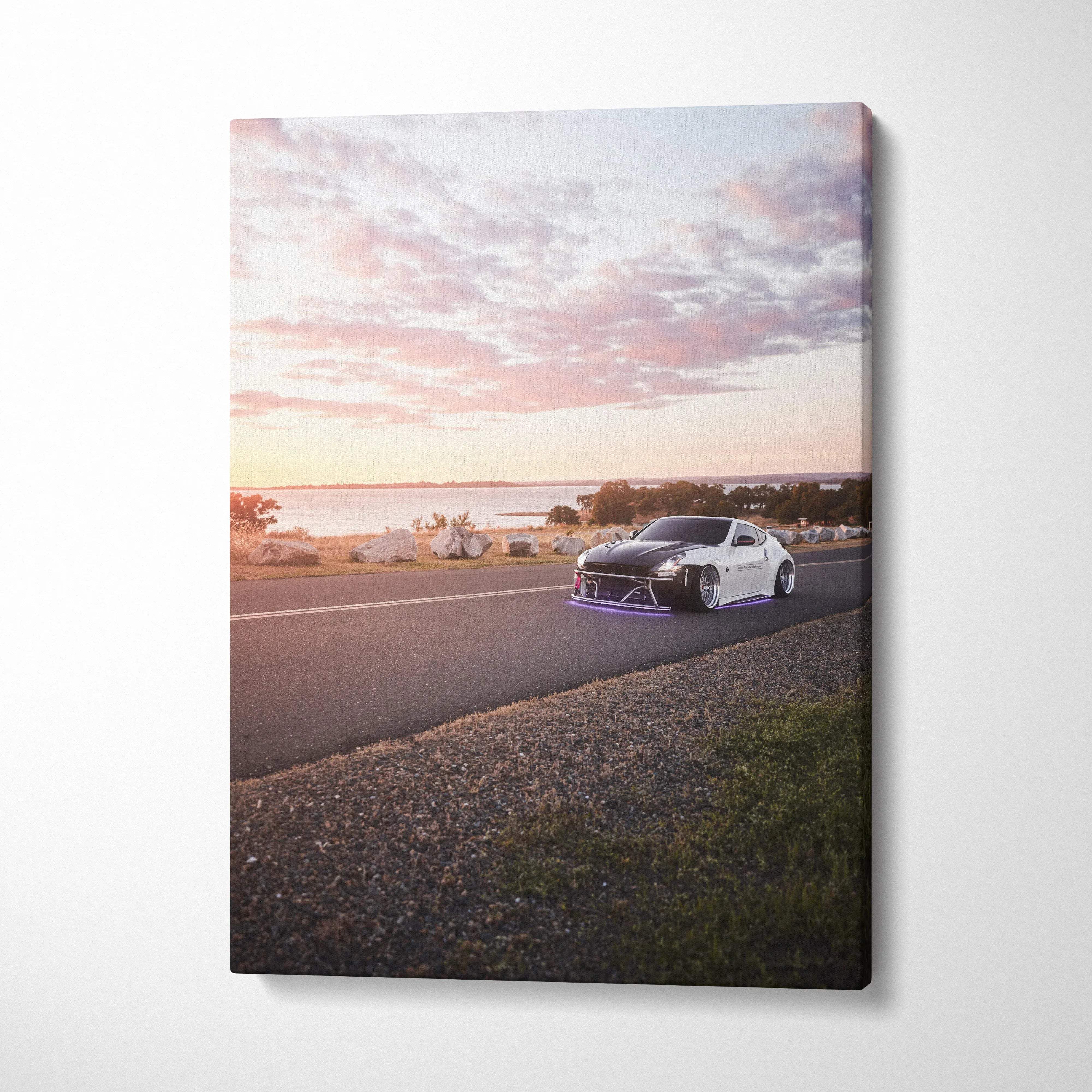 Vertical canvas wall art featuring a Nissan 370z on a scenic sunset road with soft clouds.