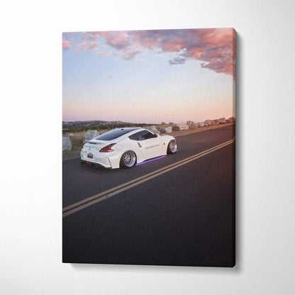 White Nissan 370z driving on road during sunset canvas wall art print.