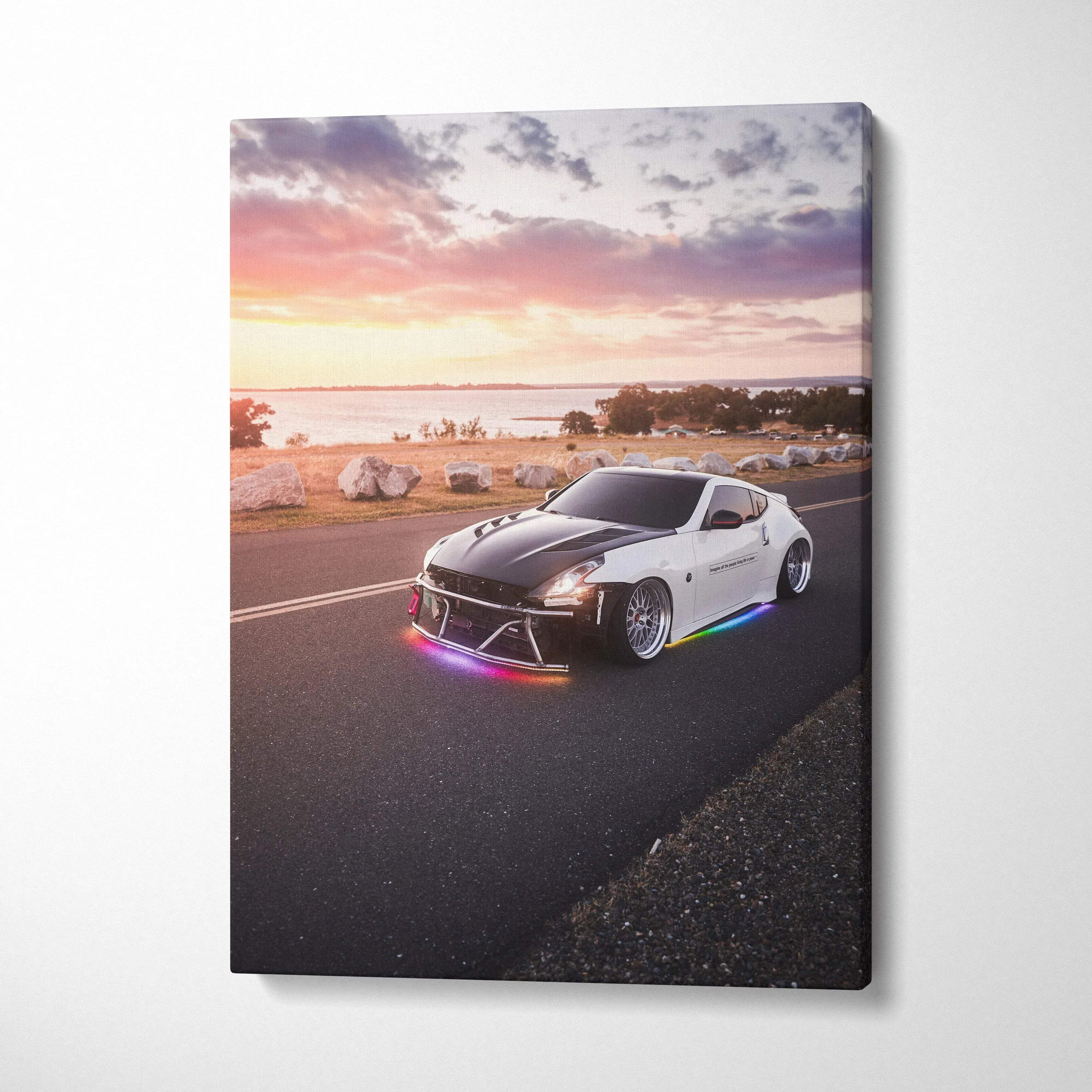 Vertical canvas art of a white Nissan 370z with neon underglow on coastal road at sunset.