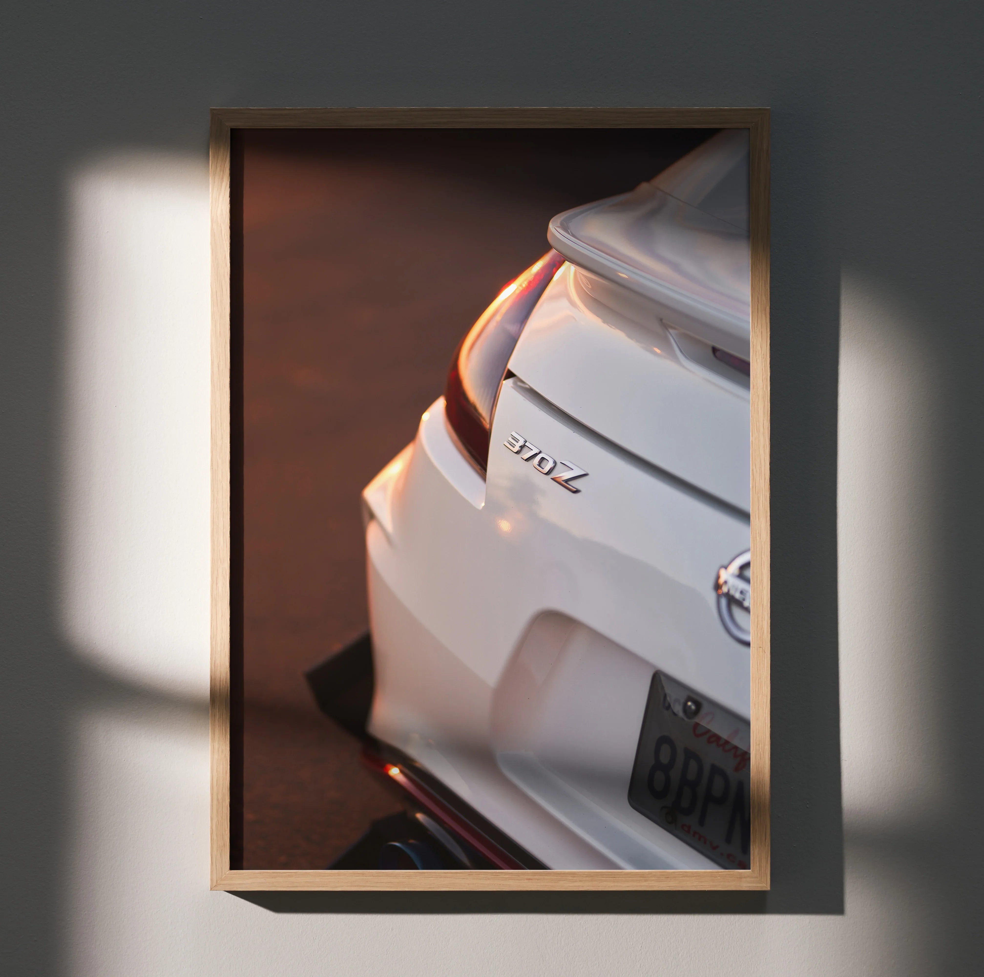 Nissan 370z close-up rear view poster wall art in wooden frame with warm lighting.
