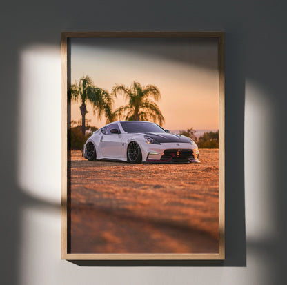 Nissan 370z poster wall art featuring sleek white car at sunset with palm trees in background.