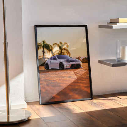 Nissan 370z poster wall art with sunset and palm trees in black frame leaning on floor.