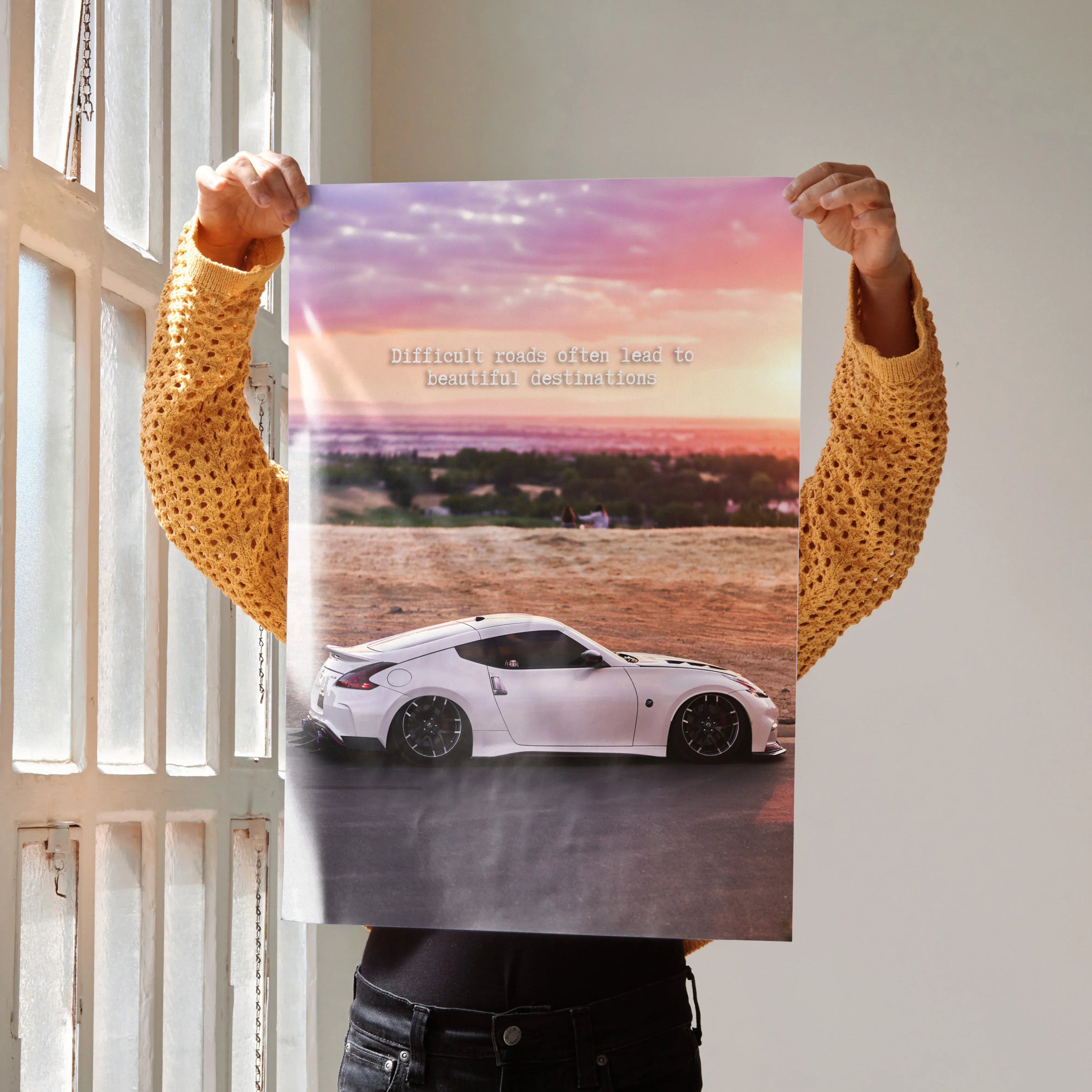 Motivational poster wall art featuring white Nissan 370z car with inspiring text against sunset background.