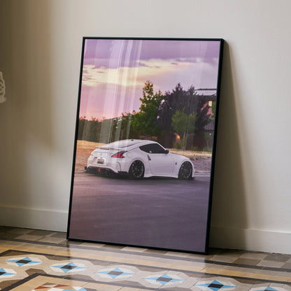 Nissan 370z poster with white car parked at sunset, framed wall art with purple sky and trees.