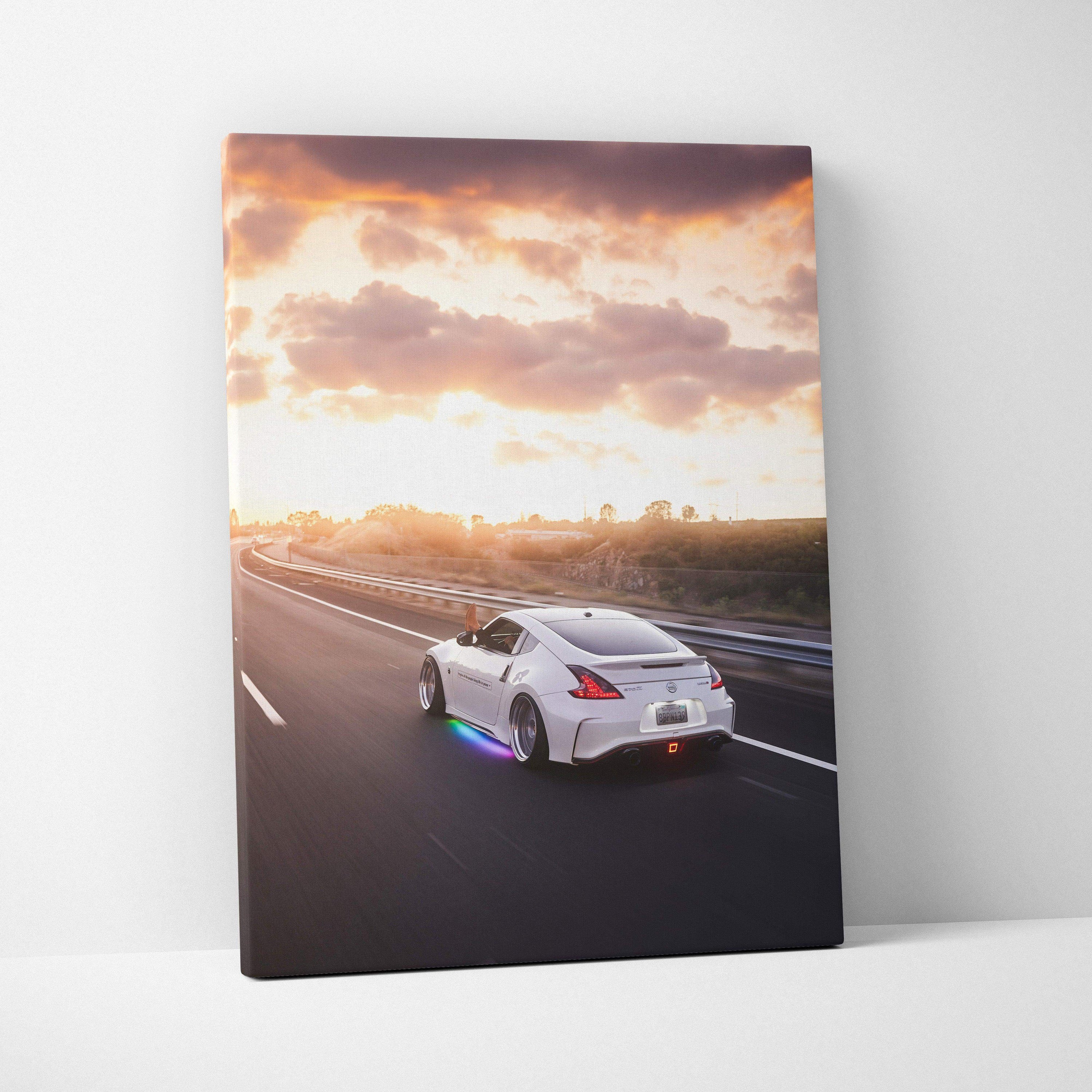 Nissan 370z driving on highway at sunset vertical canvas wall art with vibrant sky.