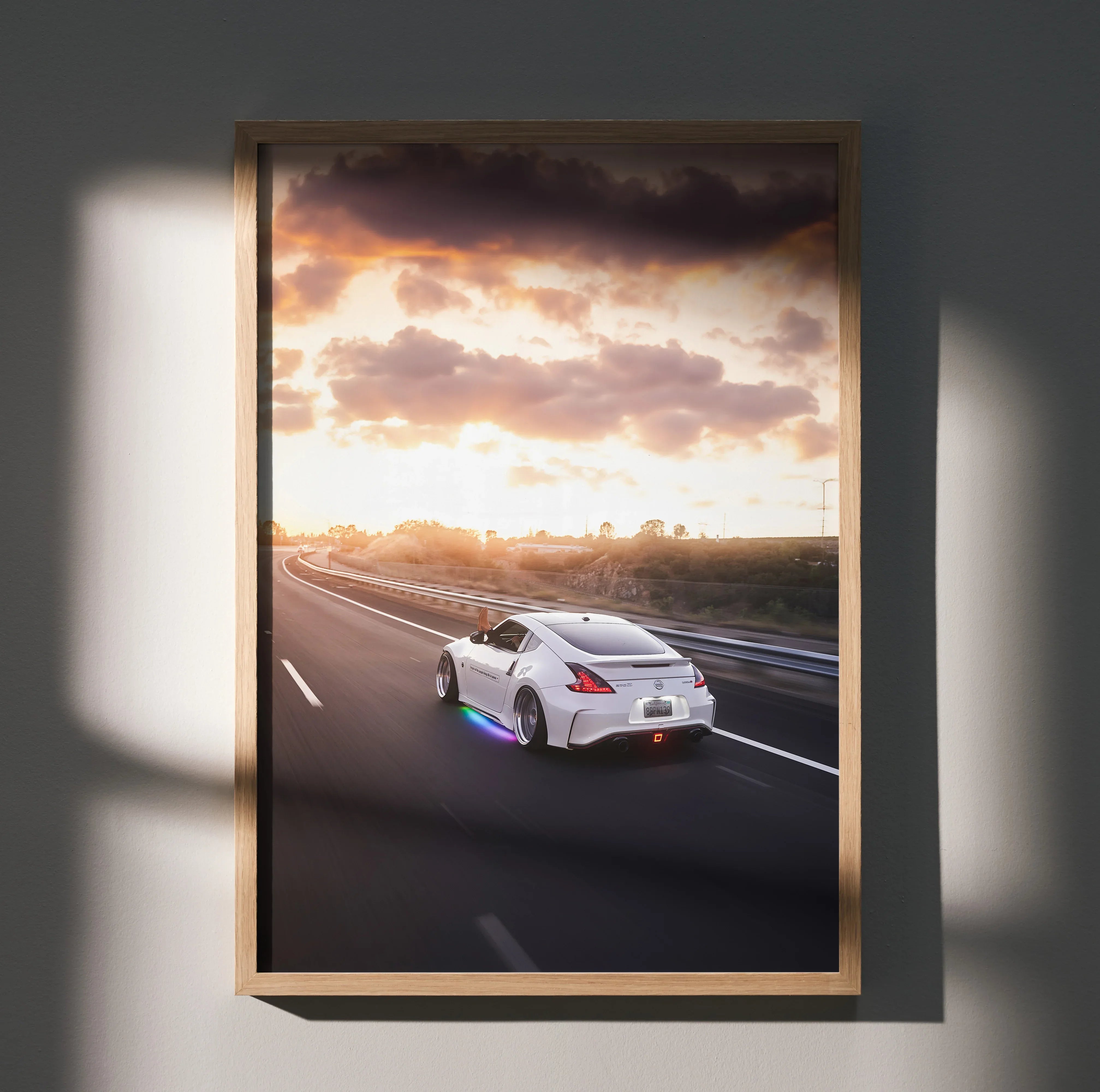 Nissan 370z driving on highway at sunset with dramatic clouds poster wall art.