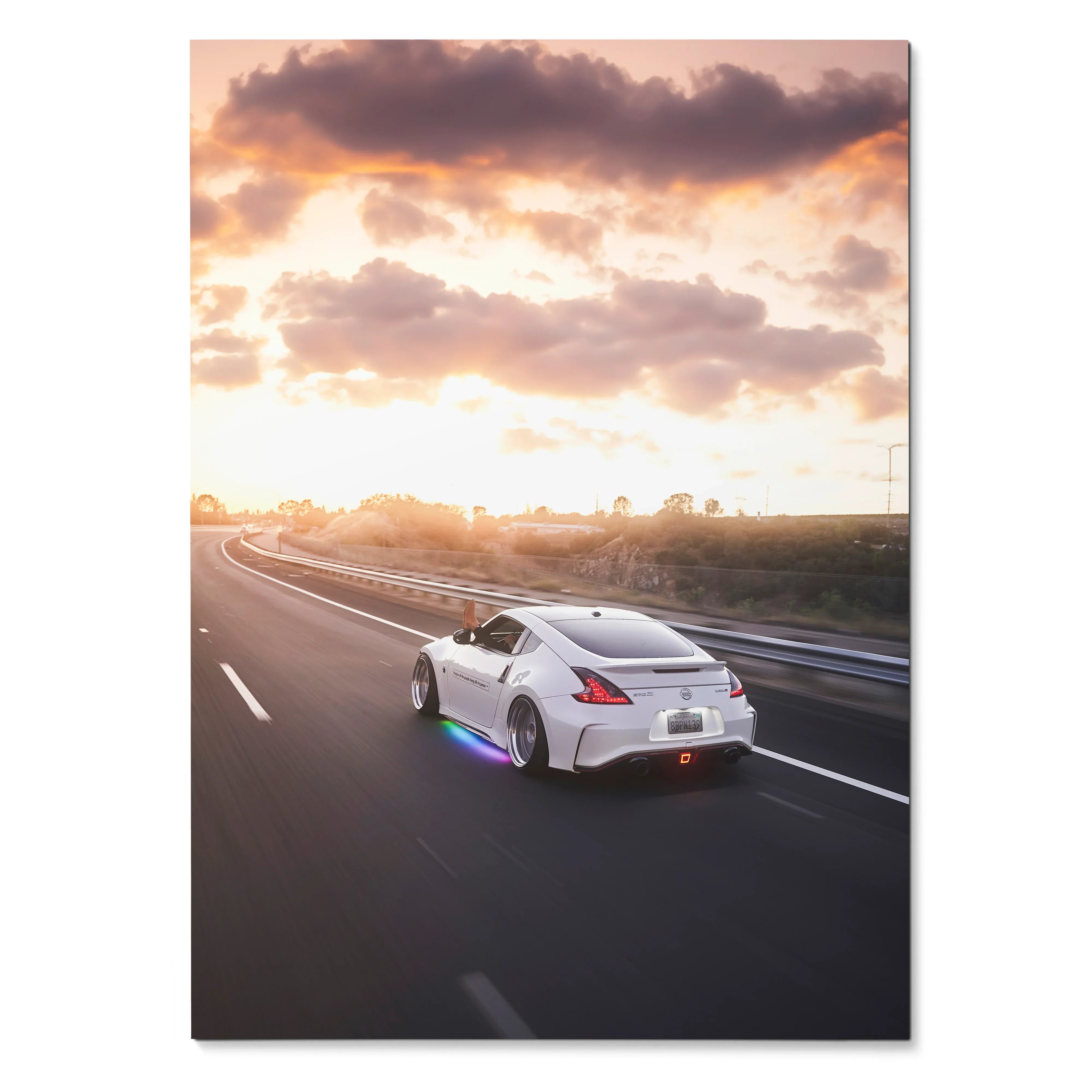 Nissan 370Z driving on highway at sunset with vibrant sky poster wall art.