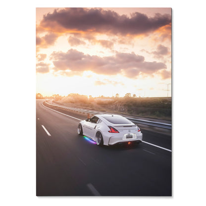 Nissan 370Z driving on highway at sunset with vibrant sky poster wall art.