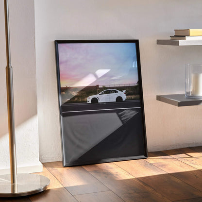 Mitsubishi Evo X poster wall art featuring white Evo 10 car against vibrant sunset sky in black frame.