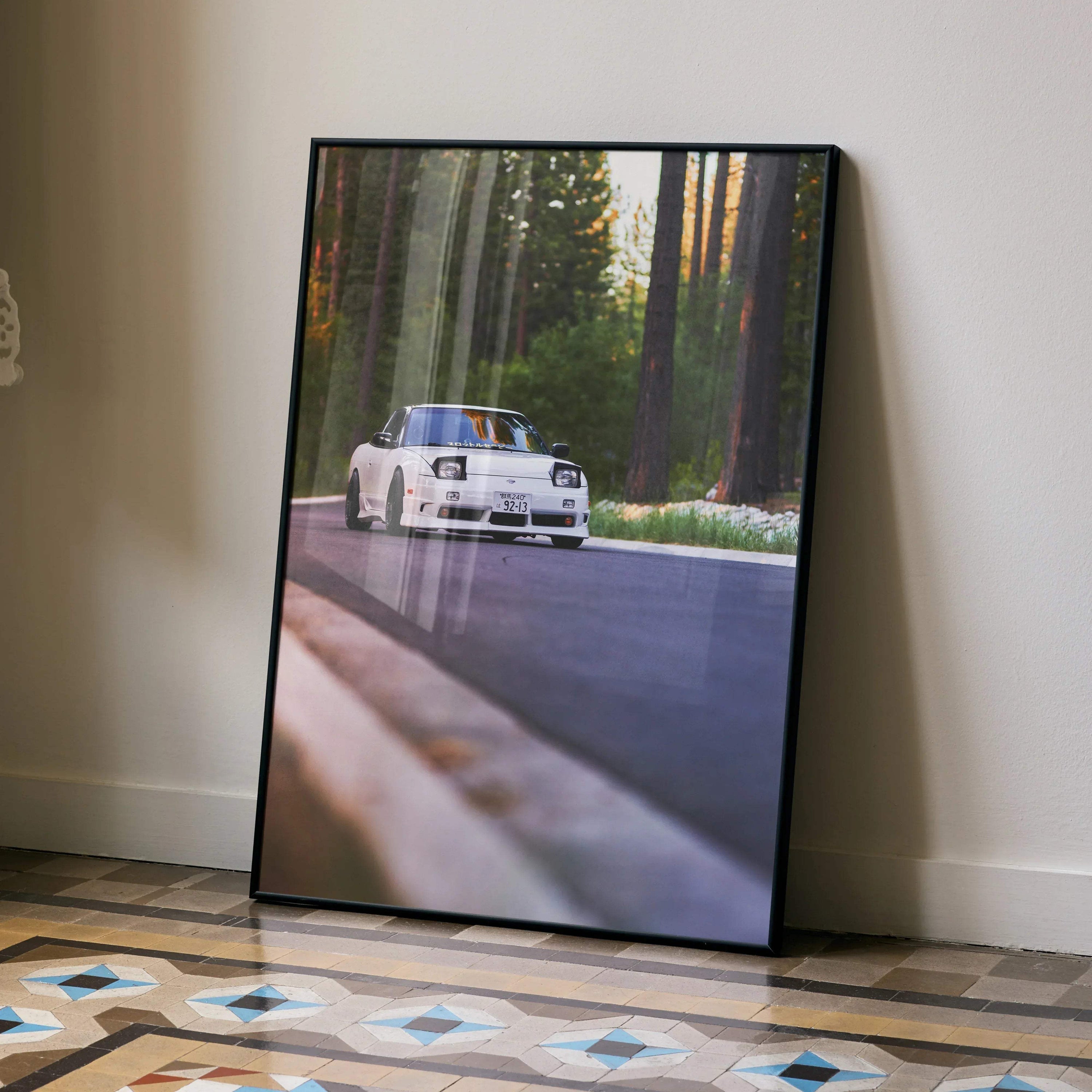 Nissan 240sx S13 Type-X poster with white car driving on forest road wall art in black frame.