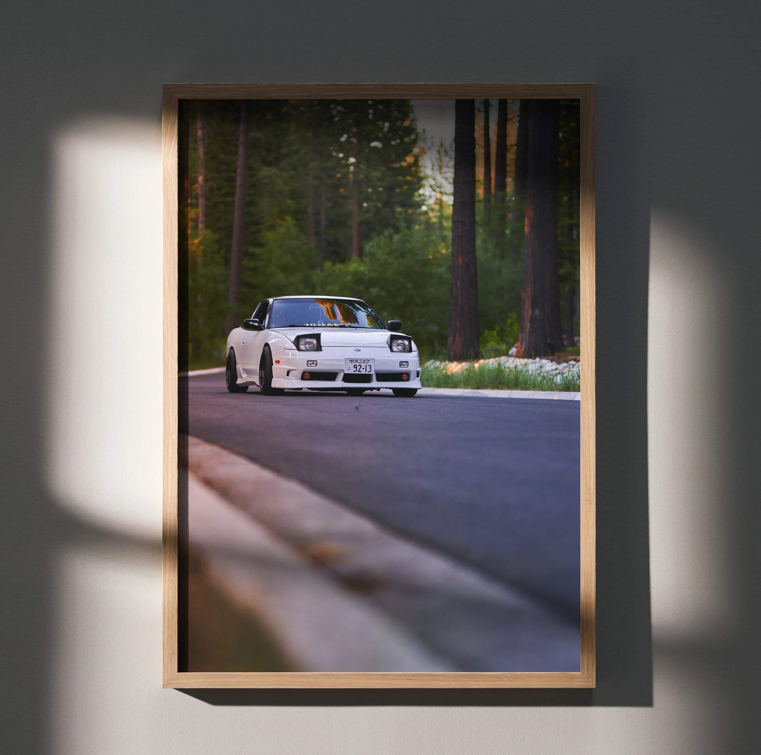 Nissan 240sx S13 Type-X driving on forest road poster wall art with natural wood frame.