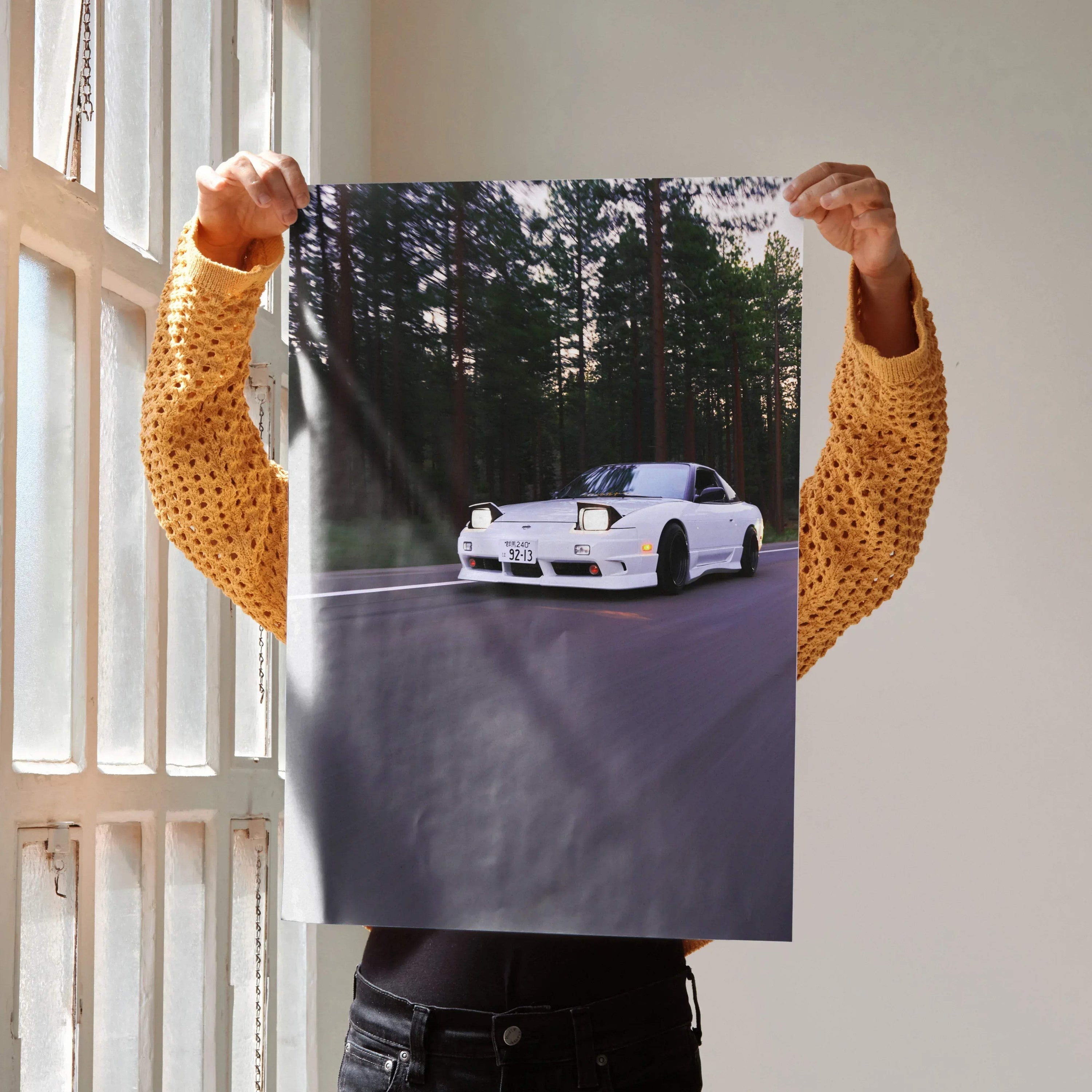 Poster wall art featuring a white Nissan 240sx S13 Type-X driving on a forest road at sunset.