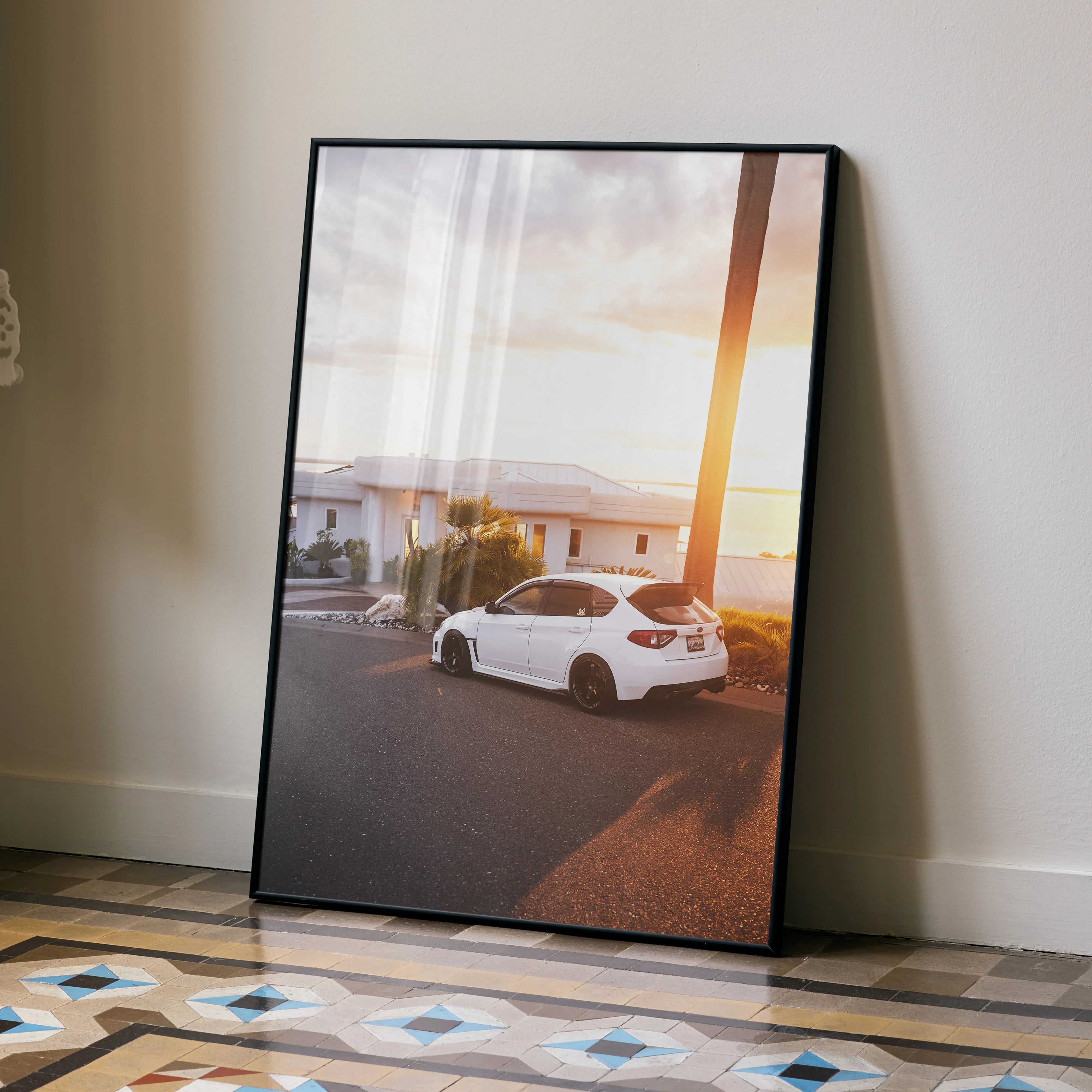 Subaru WRX STI parked at sunset with mountain backdrop poster wall art in black frame.