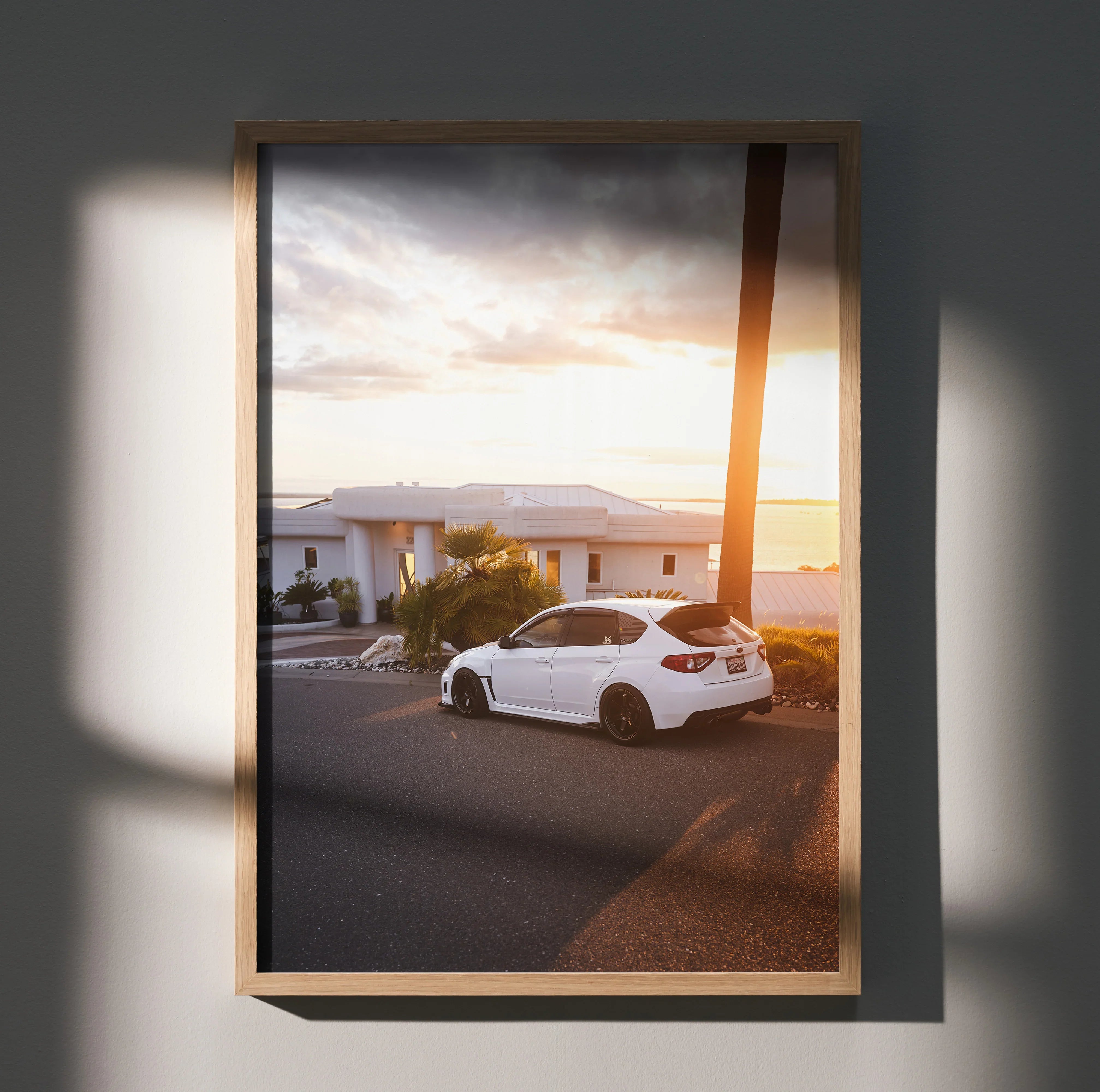 Subaru WRX STI parked on street at sunset poster wall art with warm light and modern frame.