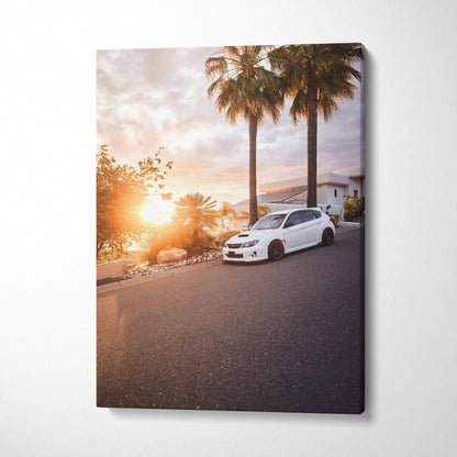White Subaru WRX STI parked beside palm trees at sunset on vertical canvas wall art.