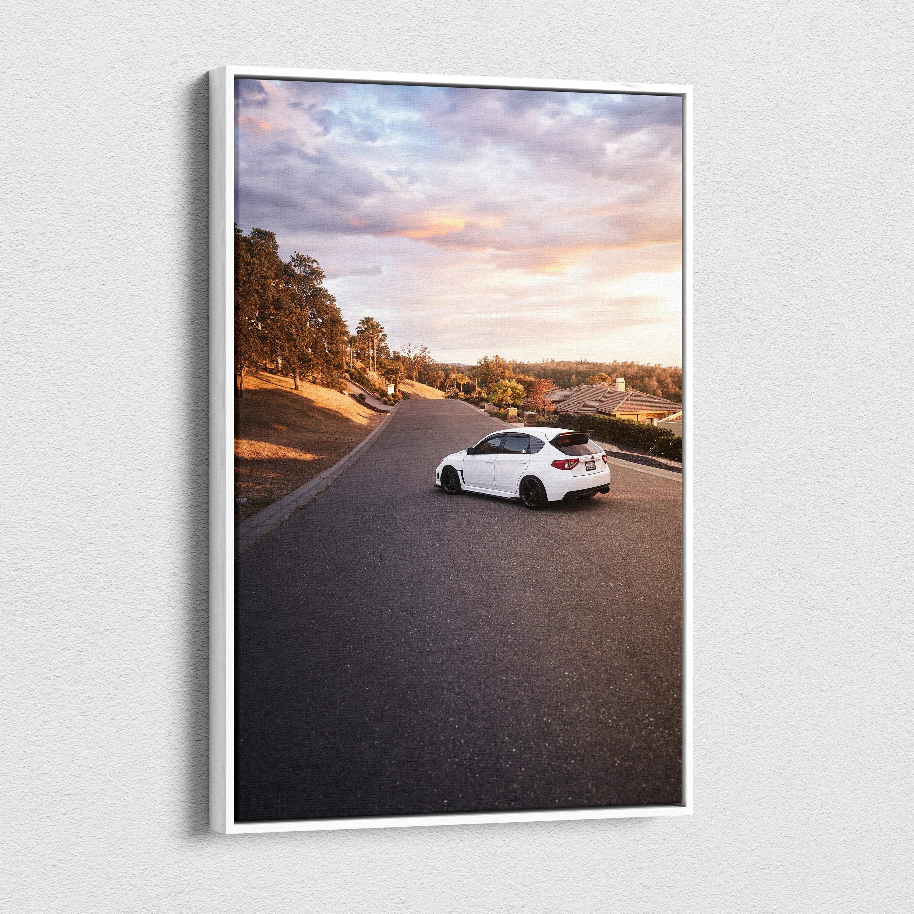 Vertical canvas art featuring a white Subaru WRX STI on a scenic road at sunset, wall art print.
