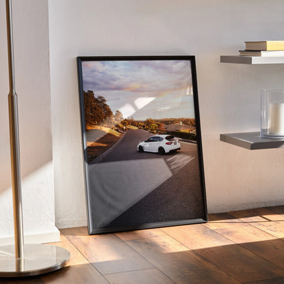 Subaru WRX STI on sunset road poster wall art in black frame leaning on floor.