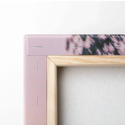Close-up of wooden-framed canvas wall art corner with visible staples and textured canvas surface.