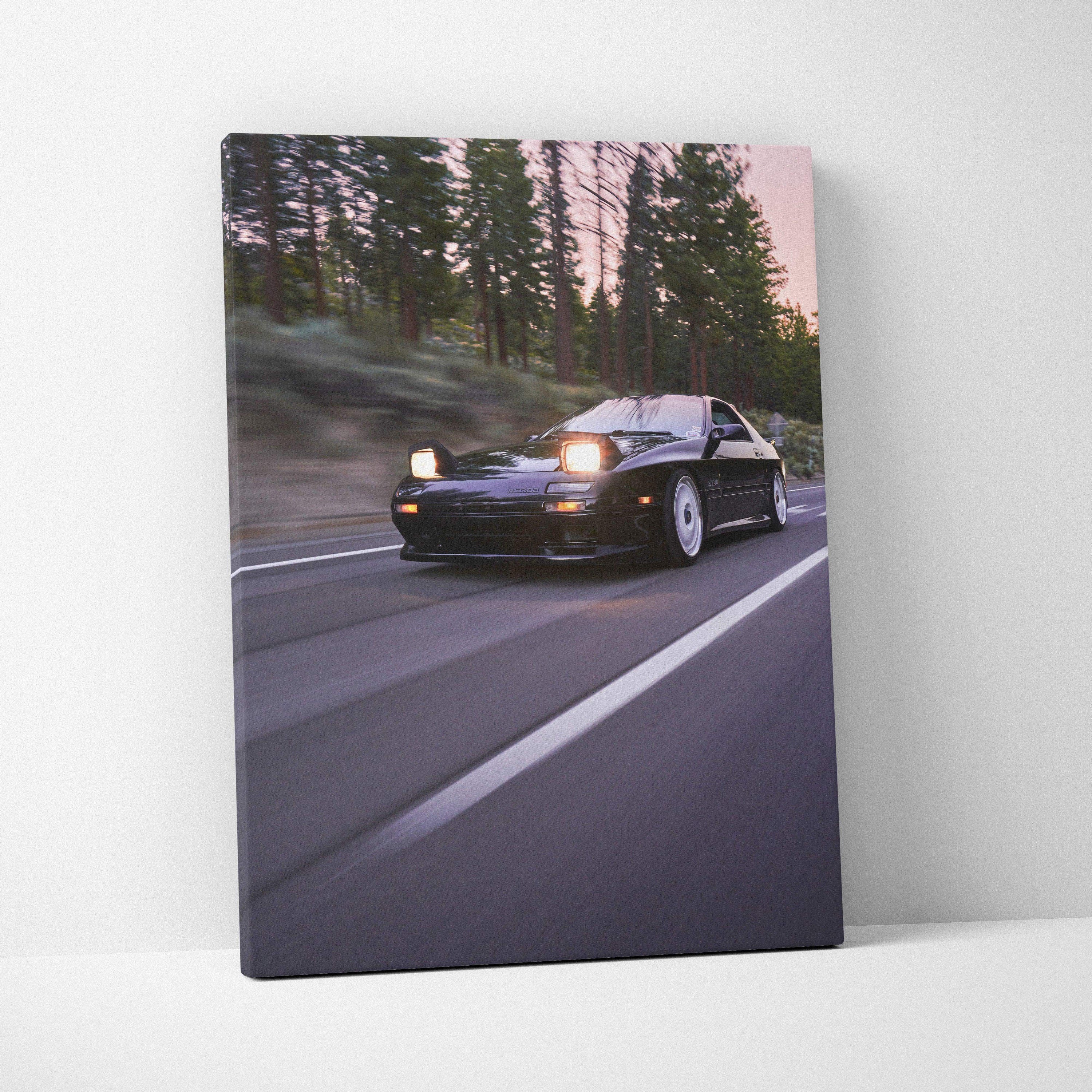 Vertical canvas wall art featuring a black Mazda FC RX7 driving on a forest road at dusk.
