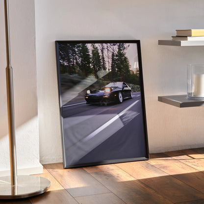 Mazda FC RX7 driving on forest road at dusk automotive poster wall art in black frame.