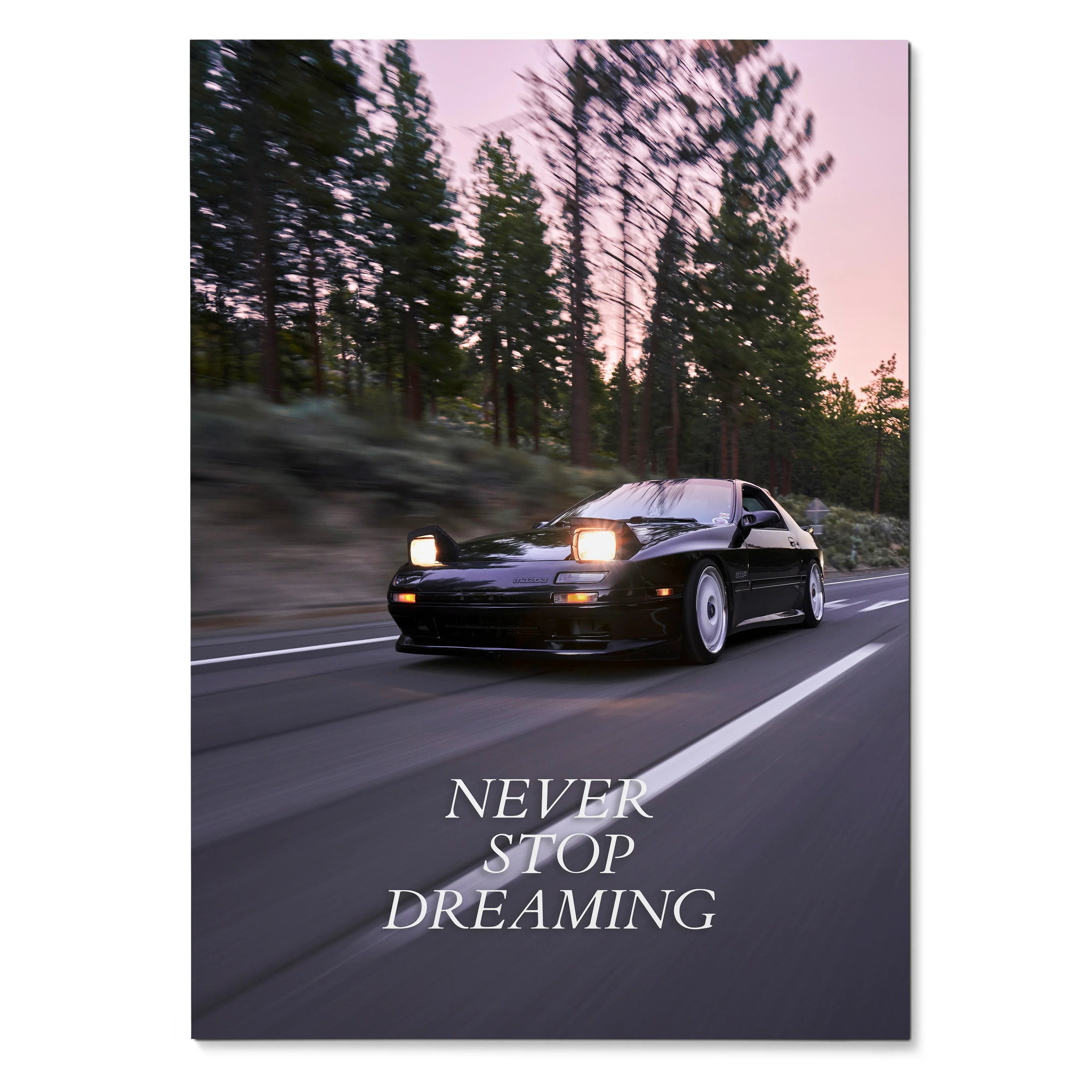 Motivational poster wall art featuring black FC Mazda RX7 driving on road with "Never Stop Dreaming" text.