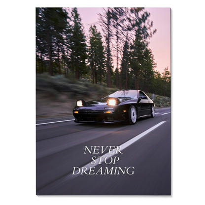 Motivational poster wall art featuring black FC Mazda RX7 driving on road with "Never Stop Dreaming" text.