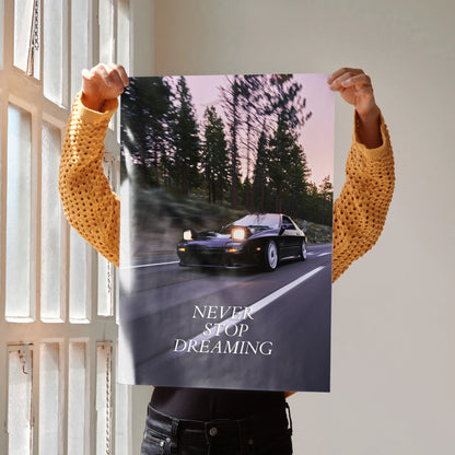 Motivational poster wall art featuring a black Mazda FC RX7 driving at sunset with "Never Stop Dreaming" text.