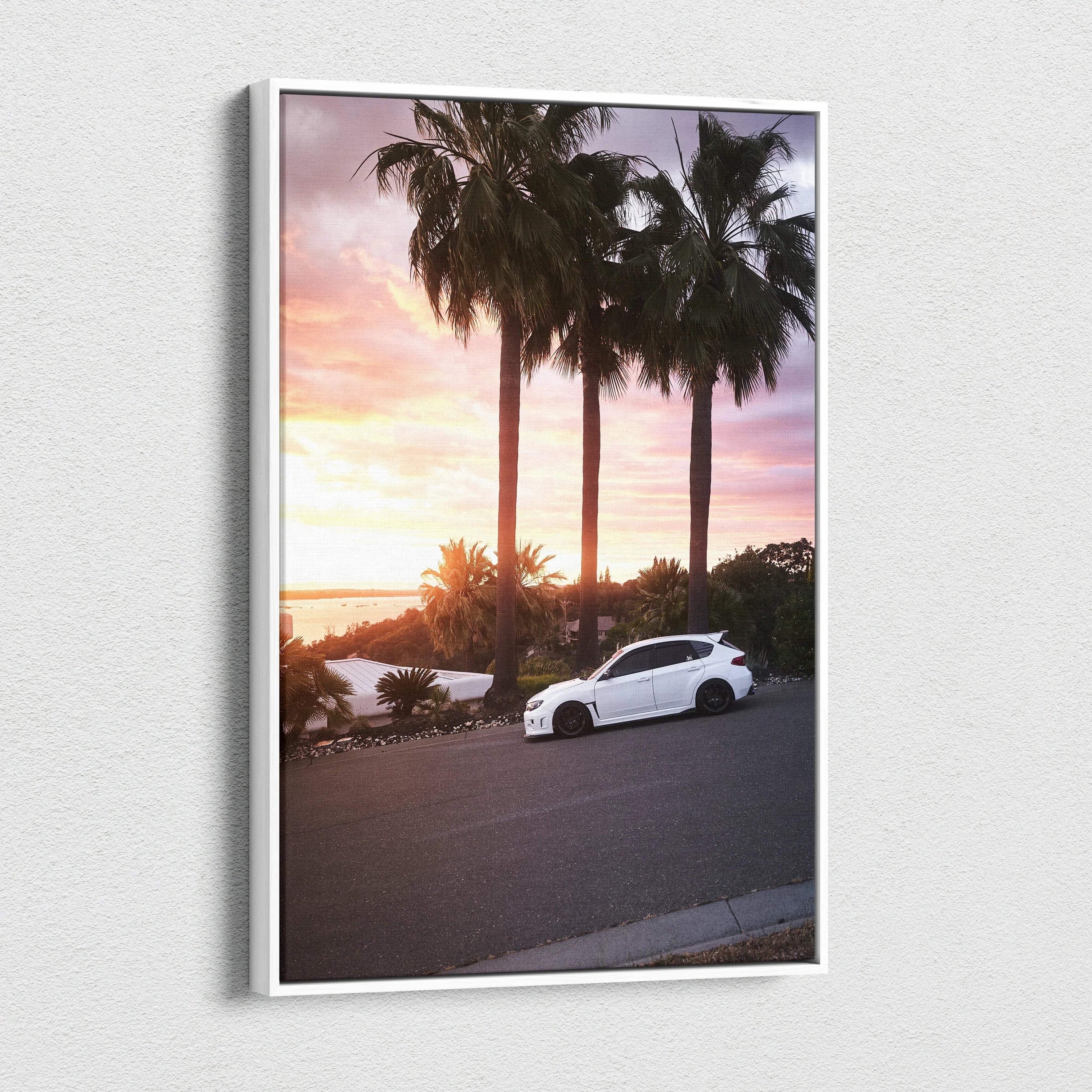 Vertical canvas wall art of a white Subaru WRX STI at sunset with palm trees and a colorful sky.