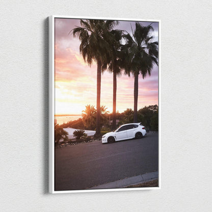 Vertical canvas wall art of a white Subaru WRX STI at sunset with palm trees and a colorful sky.