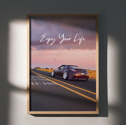 Poster wall art featuring a Nissan 350Z driving on a road at sunset with "Enjoy Your Life" text.