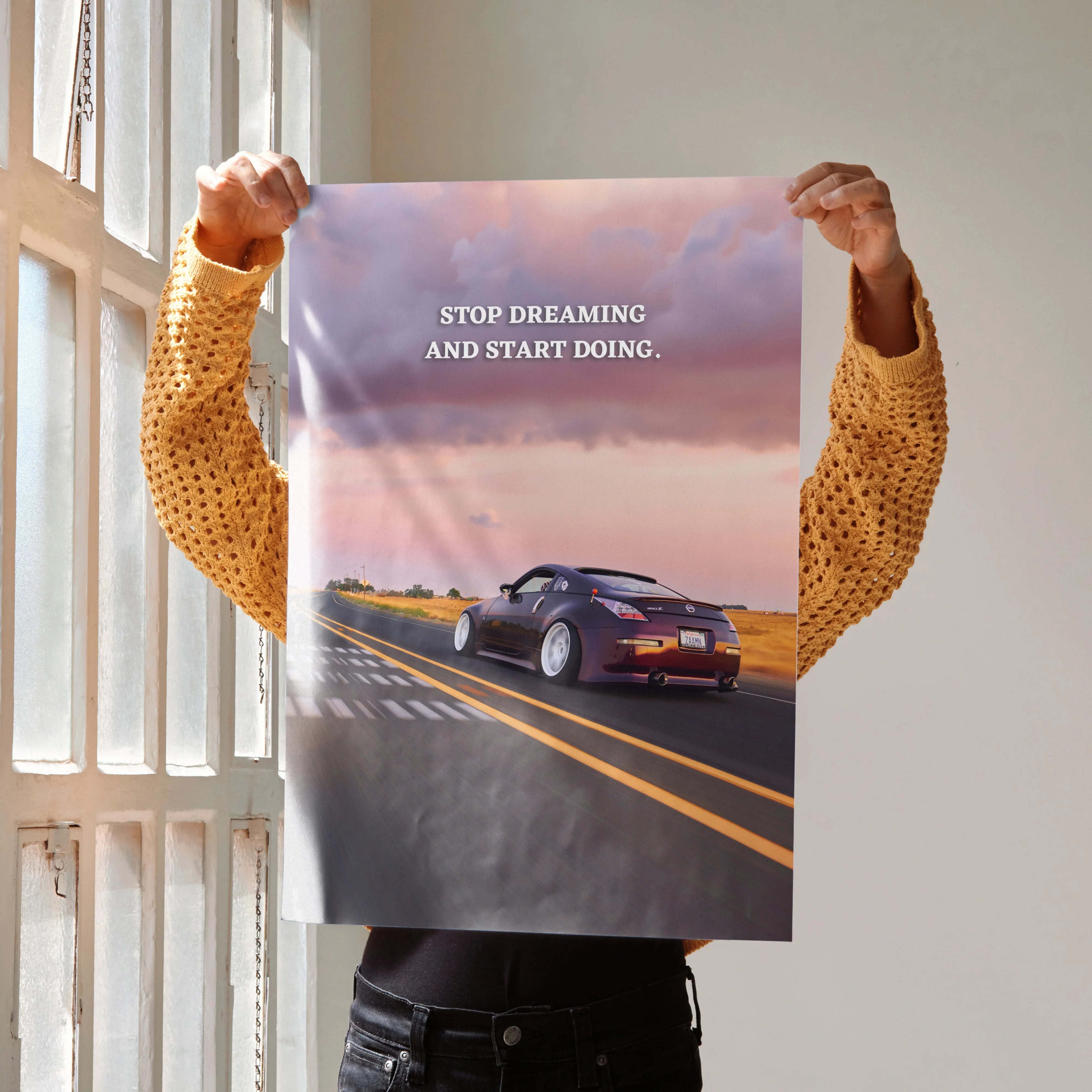 Motivational poster wall art with Nissan 350z on road at sunset and inspiring quote.