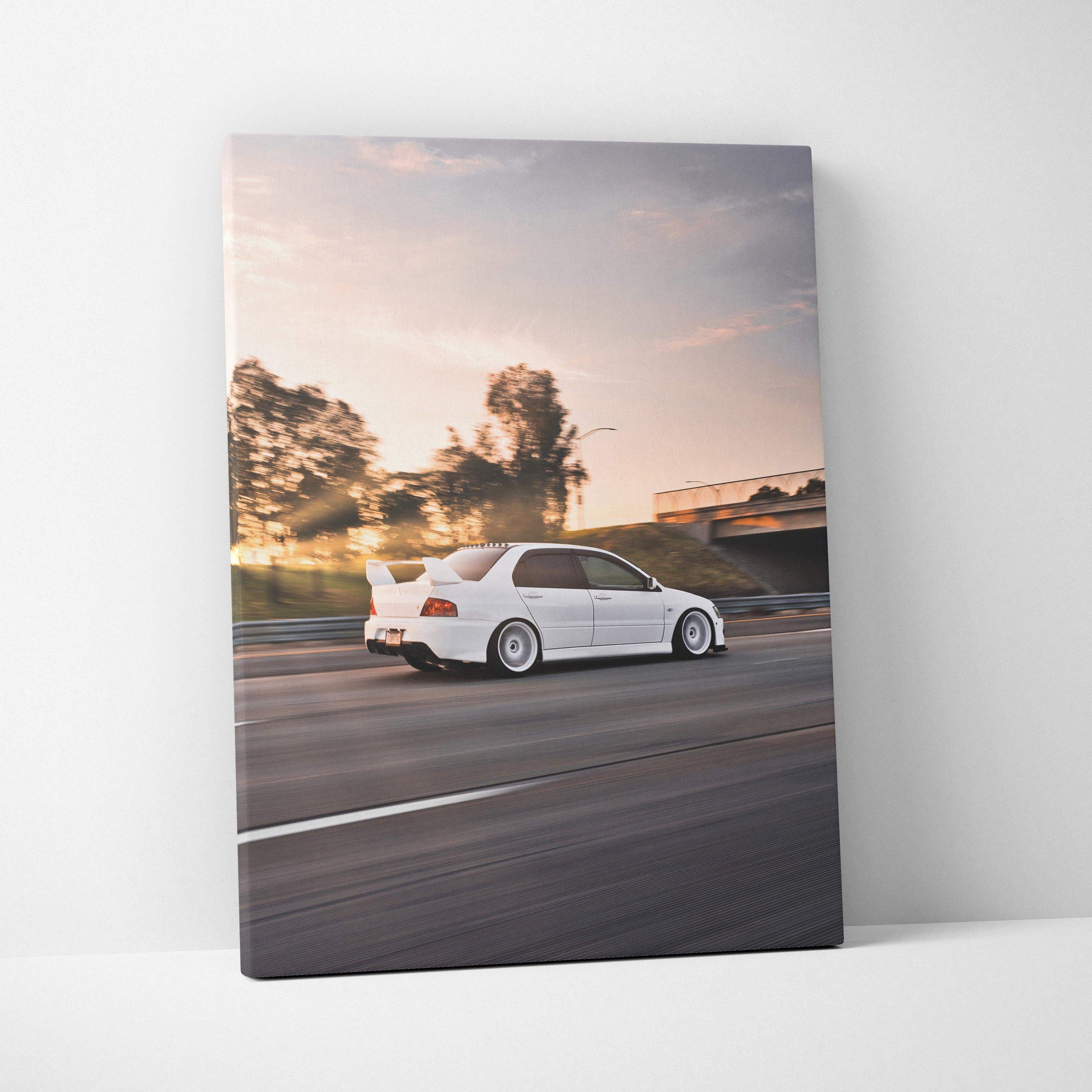 Vertical canvas art showcasing a white Mitsubishi Evo 8 speeding on a sunset highway, wall art for car enthusiasts.