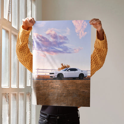 Dodge Challenger poster wall art featuring white muscle car against sunset sky with pink clouds.