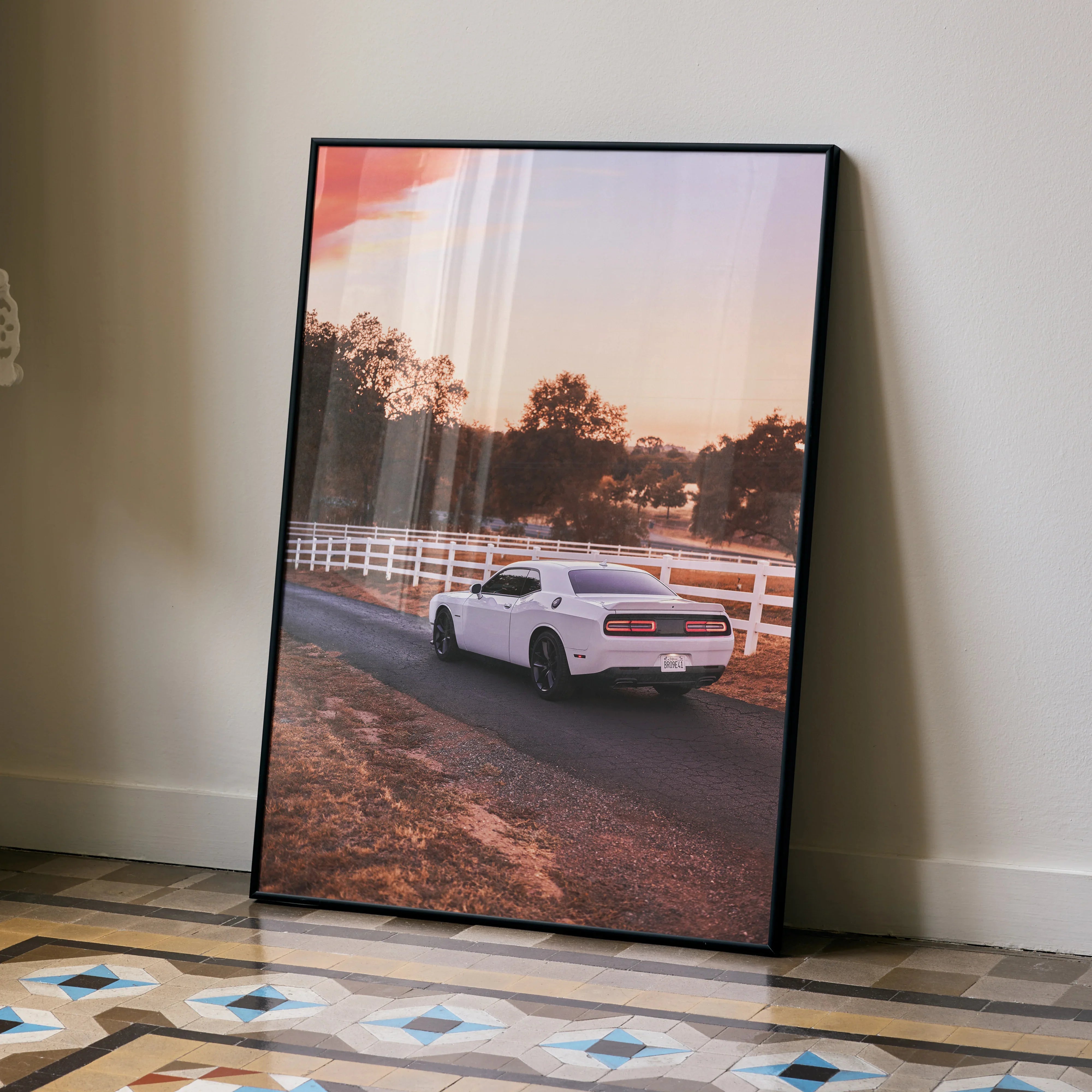 Dodge Challenger poster wall art featuring a white muscle car on a country road at sunset.