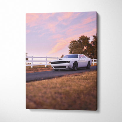 White Dodge Challenger parked on road at sunset with pink sky, printed on vertical canvas wall art.