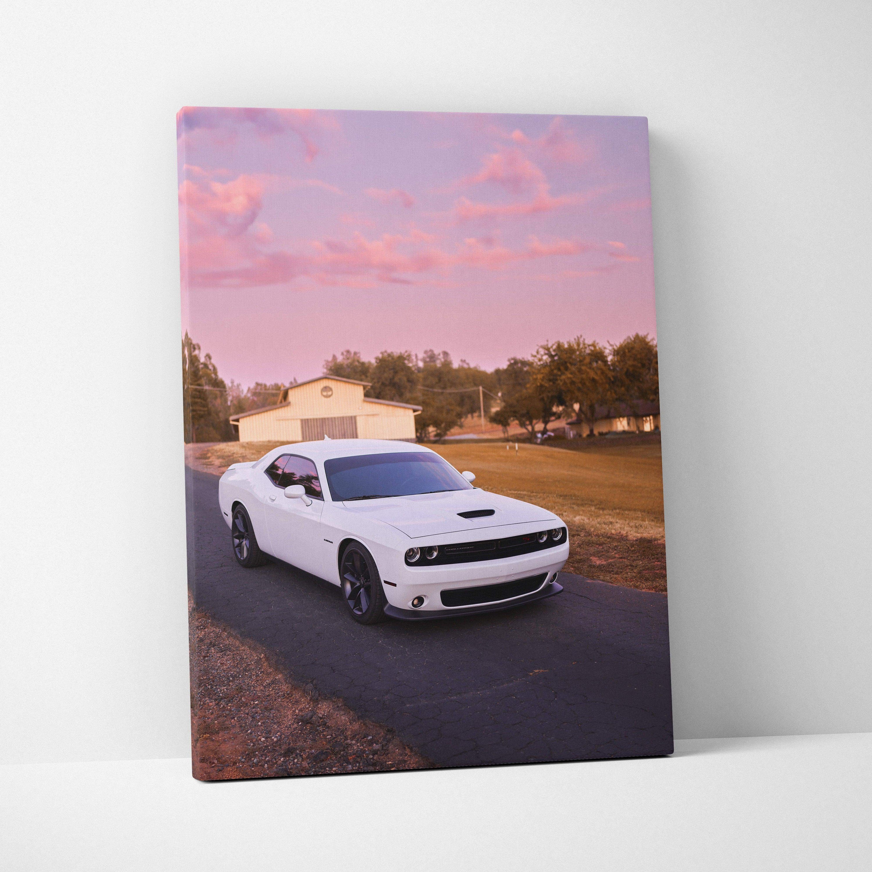 White Dodge Challenger on road at sunset with pink sky canvas wall art.