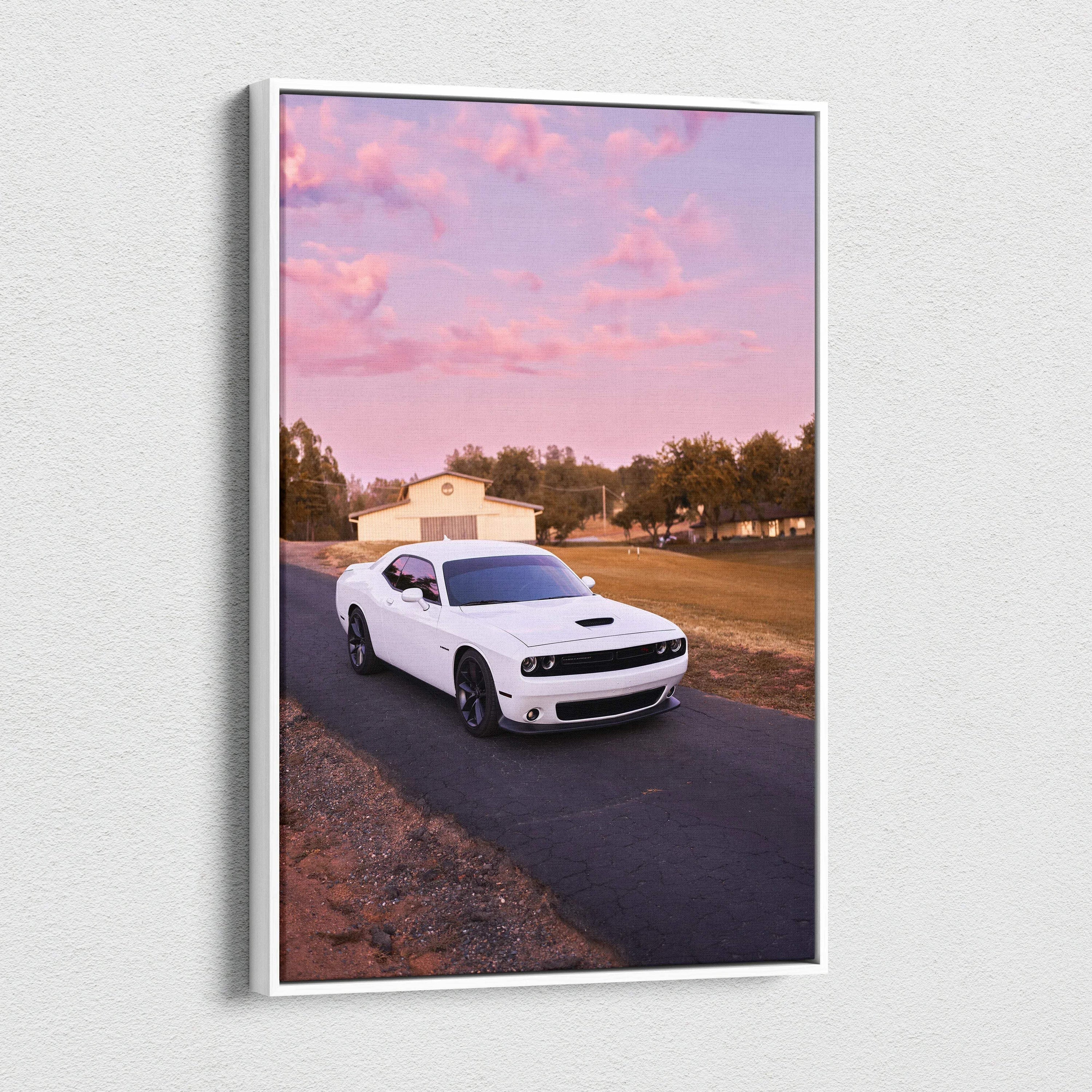 White Dodge Challenger driving on road under pink sunset sky canvas wall art.