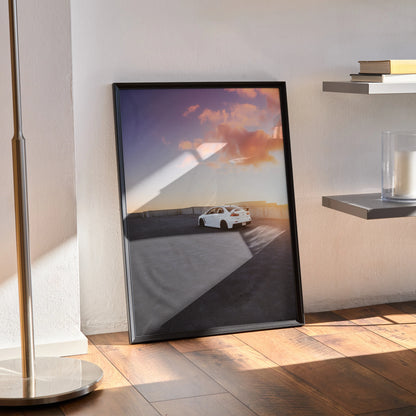 Mitsubishi Evo 10 poster wall art featuring white car at sunset with purple and orange sky in black frame.