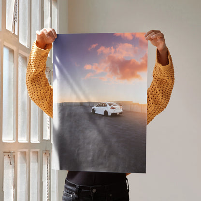 Mitsubishi Evo 10 white car on open road at sunset poster wall art with pink sky.